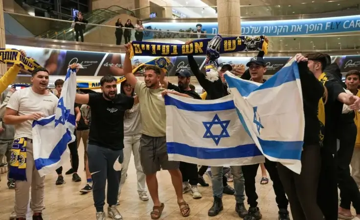 People welcome Maccabi Tel Aviv soccer fans as they arrive at Israel's Ben-Gurion International Airport on a flight from Amsterdam, where Israeli soccer fans were attacked following a match between the Israeli club and Ajax Amsterdam, in Lod, Israel, Friday, Nov. 8, 2024. (AP Photo/Tsafrir Abayov) Jew hunt