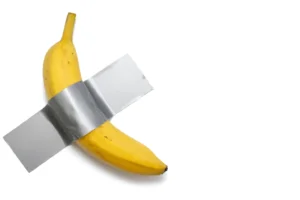 A banana duct-taped on a wall. Conceptual art. By halcon1/stock.adobe.com.