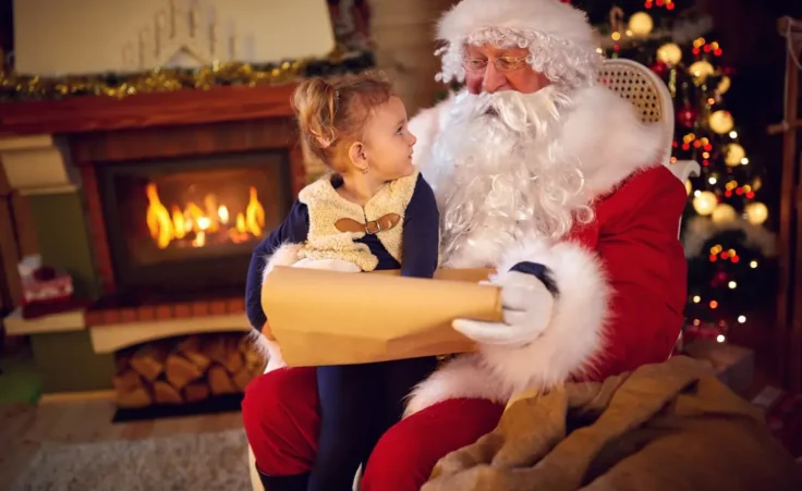 Sweet girl and Santa Claus choosing her present from list. By luckybusiness/stock.adobe.com