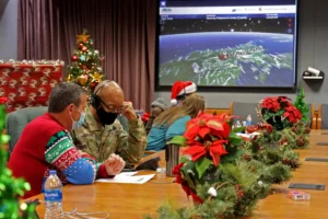 This image provided by the Department of Defense shows volunteers answering phones and emails from children around the globe during the annual NORAD Tracks Santa event on Peterson Air Force Base in Colorado Springs, Colo., Dec. 24, 2021. (Chuck Marsh/Department of Defense via AP)