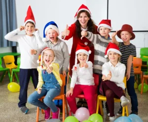 Pupils with teacher in Santa hats giving thumbs up By JackF/stock.adobe.com