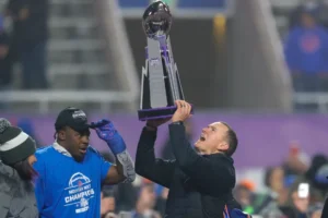 Boise State head coach Spencer Danielson celebrates with safety Seyi Oladipo, the defensive player of the game, with the Championship Trophy after their matchup against UNLV in the Mountain West Championship NCAA college football game Friday, Dec. 6, 2024, in Boise, Idaho. (AP Photo/Steve Conner)