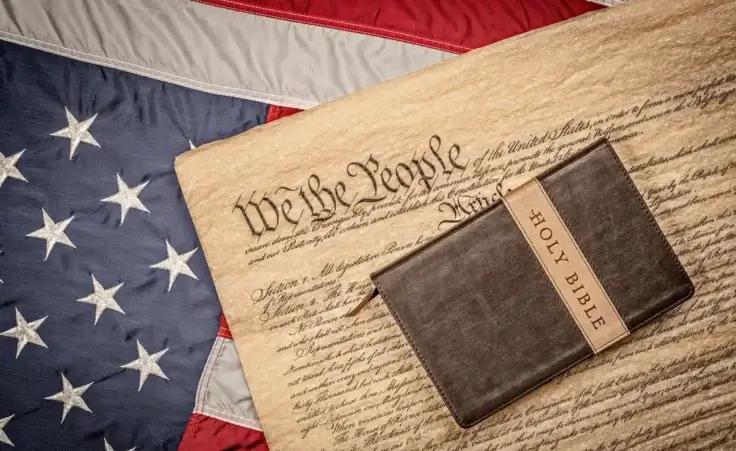 Holy Bible on constitution and American Flag By cherylvb/stock.adobe.com