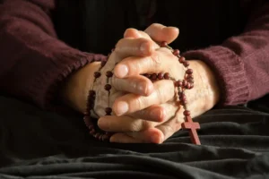 World's oldest living person clasping a rosary. By dorotaemiliac/stock.adobe.com.
