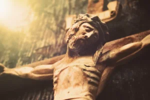 Antique wooden statue of crucified Jesus Christ against dark wooden background. By zwiebackesser/stock.adobe.com. Hamas hostages