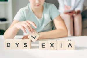 cropped view of kid with dyslexia sitting at table and playing with wooden cubes by LIGHTFIELD STUDIOS/stock.adobe.com