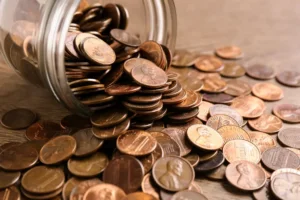 Glass jar with coins on table, closeup. Money saving concept By New Africa/stock.adobe.com