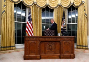 President Donald Trump walks around the Resolute desk during a ceremony in Oval Office of the White House in Washington, Wednesday, Feb. 1, 2017, for the swearing in ceremony of Rex Tillerson as Secretary of State. (AP Photo/Carolyn Kaster)