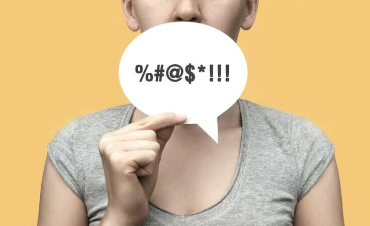 A person holding a word bubble with obscene expressions. By fidaolga/stock.adobe.com