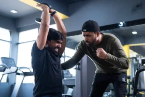 Trainer motivating athlete to push his limits during workout at gym - concept of intense exercise, bodybuilding, and determination. by WESTOCK/stock.adobe.com