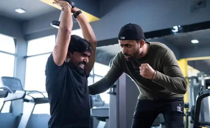 Trainer motivating athlete to push his limits during workout at gym - concept of intense exercise, bodybuilding, and determination. by WESTOCK/stock.adobe.com