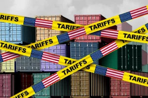 Digital image of shipping containers with "tariff" tape over them. By freshidea/stock.adobe.com. Recession US trade tariffs