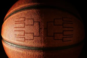 Closeup of a basketball with a tournament bracket. By zimmytws/stock.adobe.com. March Madness gambling