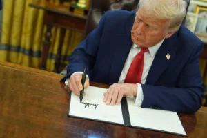 President Donald Trump signs an executive order in the Oval Office of the White House, Monday, Feb. 3, 2025, in Washington. (AP Photo/Evan Vucci)