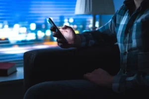 Man using phone late at night to illustrate the dangers of pornography access on mobile devices. By terovesalainen/stock.adobe.com