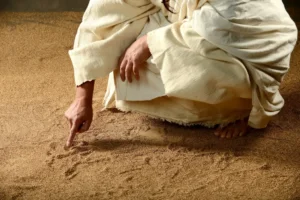 Jesus writing on the sand before his act of great compassion in John 8. By Carlos Santa Maria/stock.adobe.com