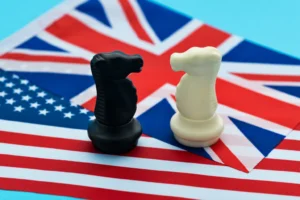 Two chess knights standing on the American flag and the UK flag. By xy/stock.adobe.com. Britain tariffs trade deal