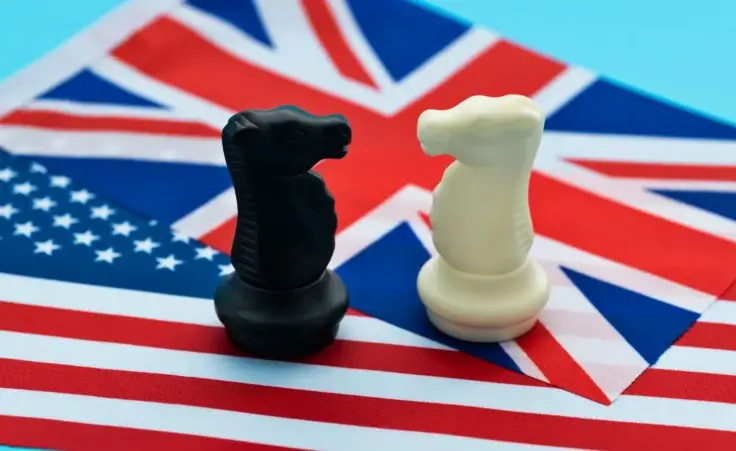 Two chess knights standing on the American flag and the UK flag. By xy/stock.adobe.com. Britain tariffs trade deal