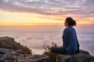A woman on a mountain top looking at morning clouds. By marvent/stock.adobe.com. Decline of woke culture