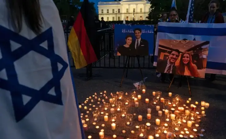 People gather to light candles in a makeshift memorial to honor Yaron Lischinsky and Sarah Milgrim who were killed as they left an event at the Capital Jewish Museum in Washington, during a candlelight vigil outside of the White House in Washington, Thursday, May 22, 2025. (AP Photo/Jose Luis Magana)