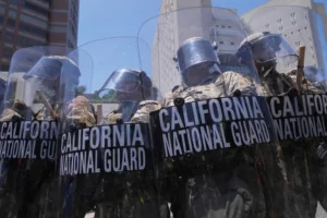 Authorities stand in tear gas while trying to clear protesters at the metropolitan detention center in downtown Los Angeles, Sunday, June 8, 2025, following last night's immigration raid protest. (AP Photo/Jae Hong)