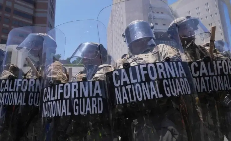 Authorities stand in tear gas while trying to clear protesters at the metropolitan detention center in downtown Los Angeles, Sunday, June 8, 2025, following last night's immigration raid protest. (AP Photo/Jae Hong)