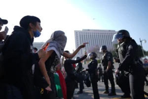 Protesters confront Los Angeles police department personnel in riot gear in downtown Los Angeles on Monday, June 9, 2025. (AP Photo/Eric Thayer)