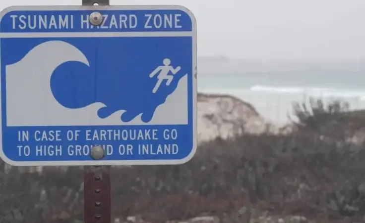 Tsunami hazard warning sign on shore of Monterey, California. By Dogora Sun/stock.adobe.com