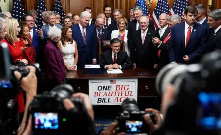 Speaker of the House Mike Johnson, R-La., surrounded by Republican members of Congress, signs President Donald Trump's signature bill of tax breaks and spending cuts, Thursday, July 3, 2025, at the Capitol in Washington. (AP Photo/Julia Demaree Nikhinson)