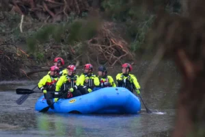 Officials ride a boat as they arrive to assist with a recovery effort at Camp Mystic along the Guadalupe River after a flash flood swept through the area Sunday, July 6, 2025, in Hunt, Texas. (AP Photo/Julio Cortez)