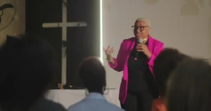 Woman delivering powerful sermon in front of a diverse audience during a church gathering. By Marco/stock.adobe.com