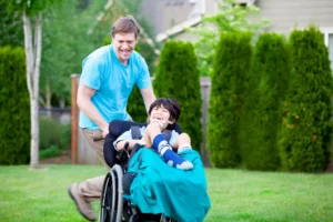 Father racing around park with disabled son in wheelchair. By Jaren Wicklund/stock.adobe.com