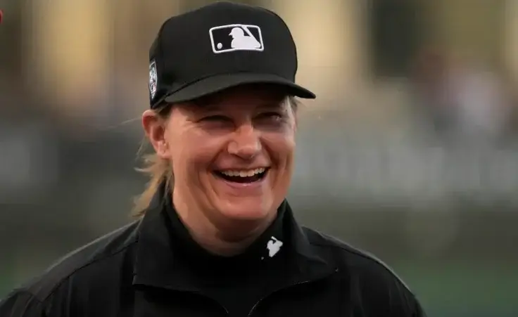 Umpire Jen Pawol smiles as she takes part in the lineup card exchange before the start of a spring training baseball game between the Washington Nationals and the Houston Astros Saturday, Feb. 24, 2024, in West Palm Beach, Fla. Pawol took a big step toward breaking the gender barrier for Major League Baseball umpires when she became the first woman in 17 years to work a big league spring training game Saturday night. (AP Photo/Jeff Roberson)