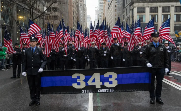 New York Fire Department officers hold flags and a banner for firefighters killed on 9/11 during the 264th New York City Saint Patrick's Day Parade, Monday, March 17, 2025 in New York. (AP Photo/Adam Gray)