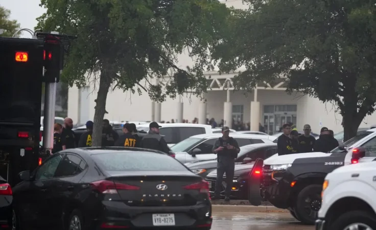 Law enforcement gather at a staging area close to a U.S. Immigration and Customs Enforcement office after a reported shooting, in Dallas on Wednesday, Sept. 24, 2025. (AP Photo/Julio Cortez)
