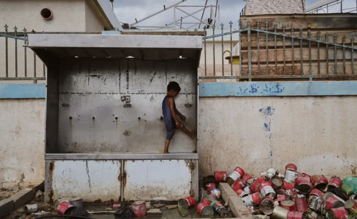 A child plays with water at a camp for displaced Palestinians in Deir al-Balah, Monday, Oct. 6, 2025. (AP Photo/Abdel Kareem Hana)