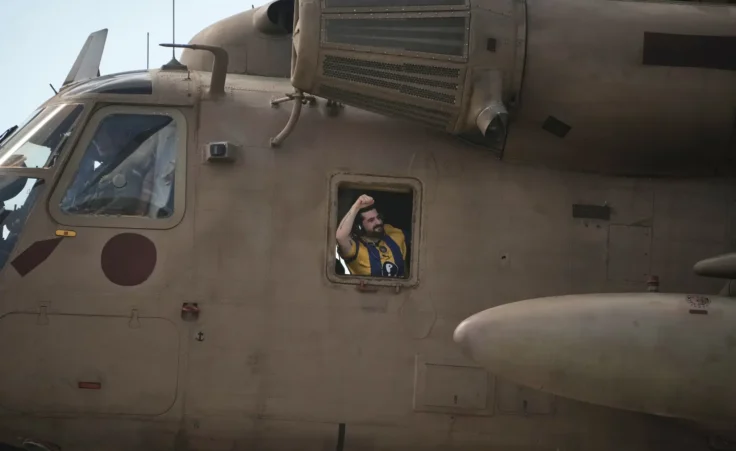 Ziv Berman, an Israeli hostage released from the Gaza Strip gestures from the window of a helicopter landing at the Sheba Medical Center in Ramat Gan, Israel, Tuesday, June 7, 2016. (AP Photo/Leo Correa)