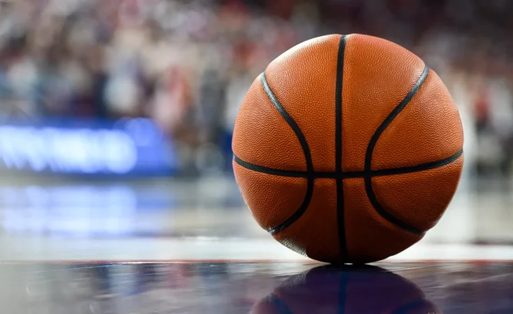 Basketball on hardwood court floor in basketball arena. By MykCrawford/stock.adobe.com. NBA gambling scandal sports betting