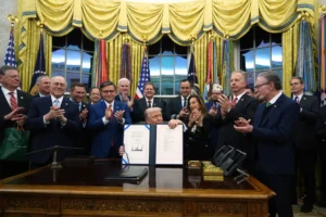 President Donald Trump displays the signed the funding bill to reopen the government, in the Oval Office of the White House, Wednesday, Nov. 12, 2025, in Washington. (AP Photo/Jacquelyn Martin) shutdown