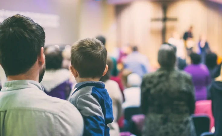 Father and son attend a revival service at church. By tutye/stock.adobe.com.