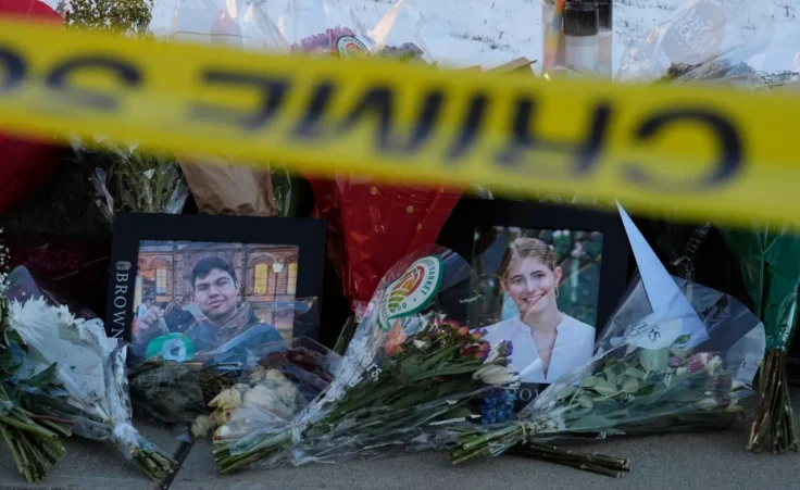 Photos of Brown University shooting victims MukhammadAziz Umurzokov, left, and Ella Cook, are seen amongst flowers at a makeshift memorial outside the Engineering Research Center, Tuesday, Dec. 16, 2025, in Providence, R.I. (AP Photo/Robert F. Bukaty)