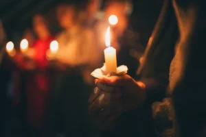 Girl holding candle during Christmas Eve church service. By evgavrilov/stock.adobe.com. church mental wellness Christmas