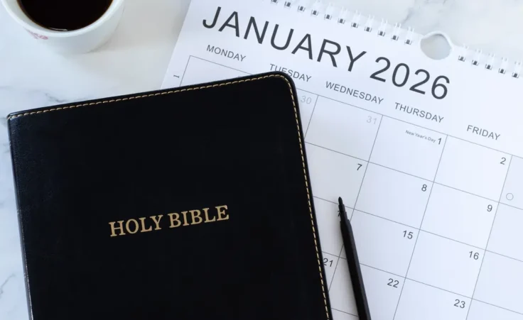 The Holy Bible next to a January 2026 calendar and coffee cup to illustrate making annual spiritual goals & resolutions. By Marinela/stock.adobe.com