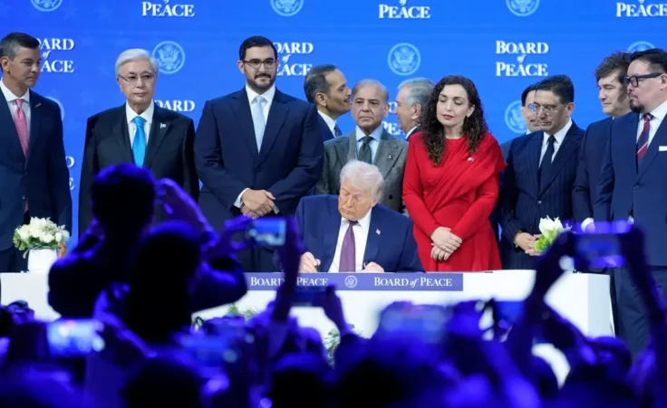 US President Donald Trump signs the charter of his Board of Peace initiative at the Annual Meeting of the World Economic Forum in Davos, Switzerland, Thursday, Jan. 22, 2026. (AP Photo/Markus Schreiber)