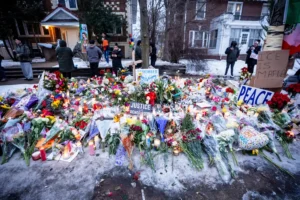People pay their respects at a memorial honoring a woman who was fatally shot by an Immigration and Customs Enforcement officer the day before, near the site of the shooting in Minneapolis, Thursday, Jan. 8, 2026. (Christopher Katsarov/The Canadian Press via AP)