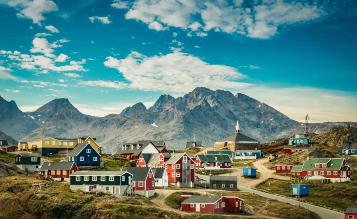 Small town on the east coast of Greenland, featuring colorful houses against a mountainous backdrop. By Elizabeth/stock.adobe.com.