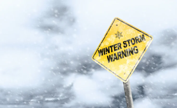 Sign that reads "Winter Storm Warning" with snowfall and a snowy background. By ronniechua/stock.adobe.com.