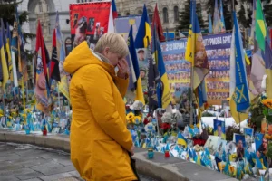 A woman reacts at the memorial to the fallen Ukrainian soldiers on Independence Square on the fourth anniversary of Russia's full-scale invasion in Kyiv, Ukraine, Tuesday, Feb. 24, 2026. (AP Photo/Efrem Lukatsky)