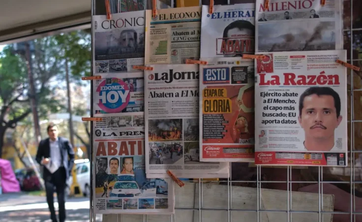 Newspapers hang on display for sale in Mexico City, Monday, Feb. 23, 2026, a day after the Mexican army killed Jalisco New Generation Cartel leader Nemesio Oseguera Cervantes, known as "El Mencho." (AP Photo/Jon Orbach)