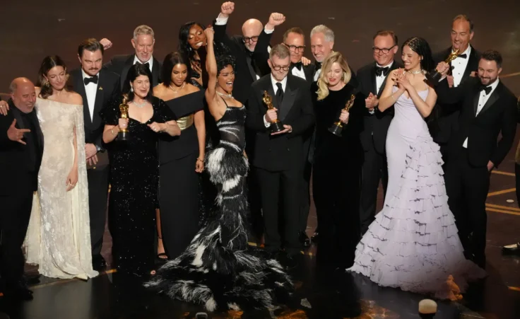 Jose Antonio Garcia, from left, Florencia Martin, Leonardo DiCaprio, Cassandra Kulukundis, Regina Hall, Shayna McHale, Teyana Taylor, Michael Bauman, Paul Thomas Anderson, Anthony Carlino, Will Weike, Sara Murphy, Chase Infiniti, Christopher Scarabosio, and Andy Jurgensen accept the award for best picture award for "One Battle After Another" during the Oscars on Sunday, March 15, 2026, at the Dolby Theatre in Los Angeles. (AP Photo/Chris Pizzello)